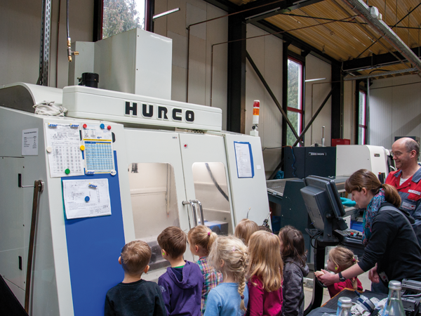 Kindergartenkinder schauen sich eine CNC-Maschine an